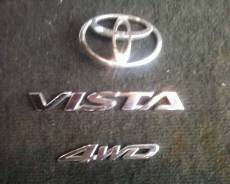 Эмблема багажника. Toyota Vista Ardeo, SV50, SV55, ZZV50, AZV50, AZV55 Toyota Vista, SV50, AZV55, ZZV50, AZV50, SV55 Двигатели: 3SFE, 1AZFSE, 3SFSE, 1...