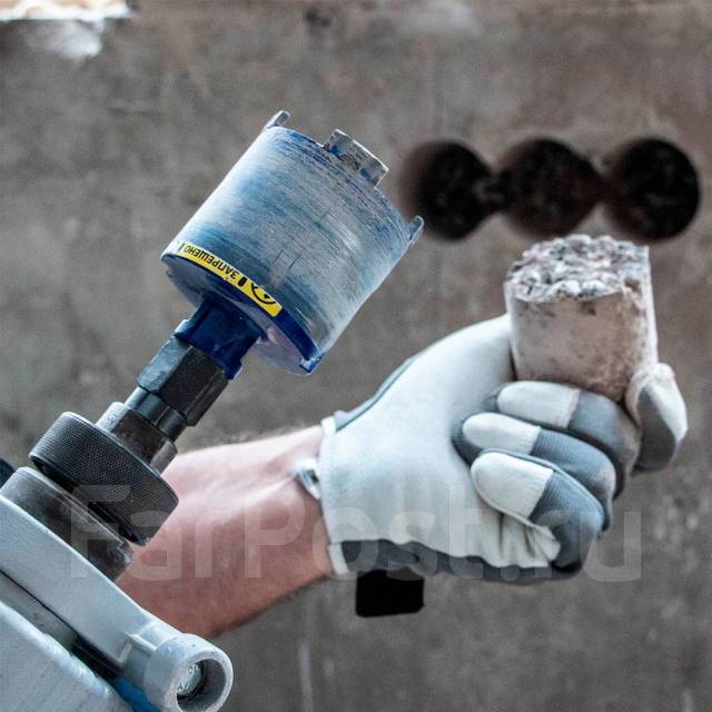 рука мастера с алмазной коронкой для бурения кирпича